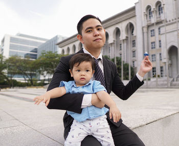 Portrait of father and son in city