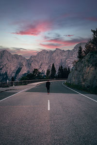 Rear view of man on road against mountain range