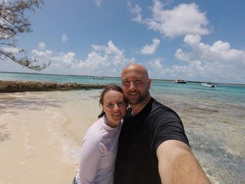 Portrait of friends standing on shore at beach