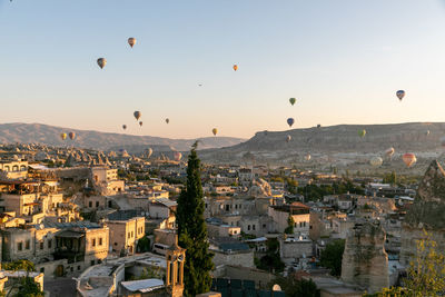 Hot air balloons flying over buildings in city