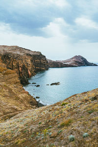 Scenic view of sea and mountains against sky