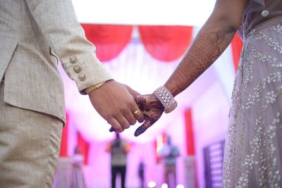 Midsection of couple holding hands