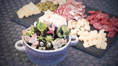 Variety of cheese and sausages cut on granite tray.