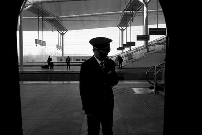 Man standing by train at railroad station