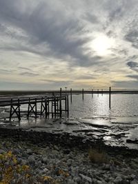 Pier on sea against sky during sunset