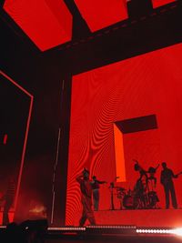 Silhouette people standing by illuminated stage at night