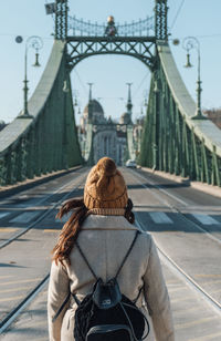 Woman standing in front of liberty bridge in budapest, hungary