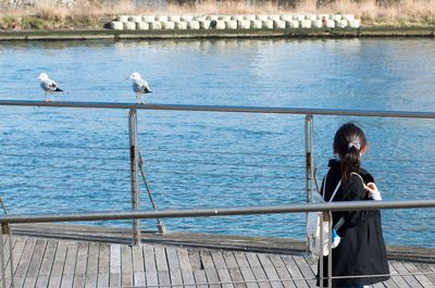 Woman standing on pier by lake