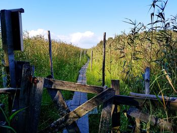Wooden fence on field against sky