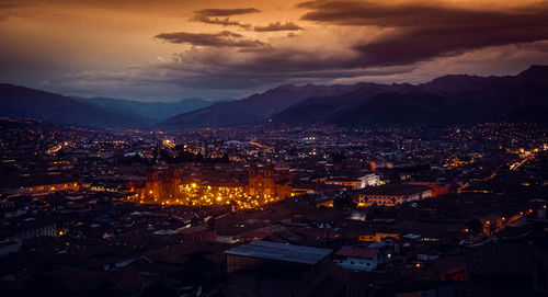 High angle view of illuminated buildings in city at sunset