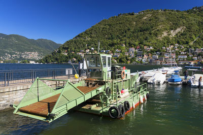 Boats moored in lake against plants