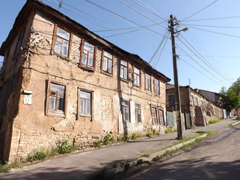 Road by buildings in city against sky