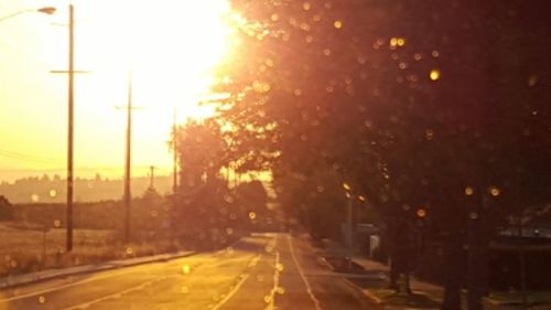 Road passing through city at sunset