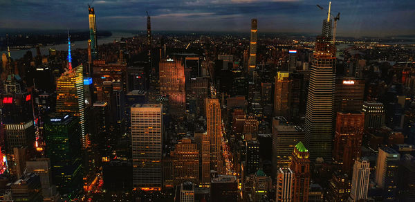 Illuminated cityscape against sky at night