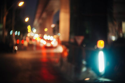 Defocused image of illuminated city street at night