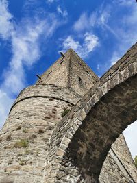 Low angle view of old building against cloudy sky