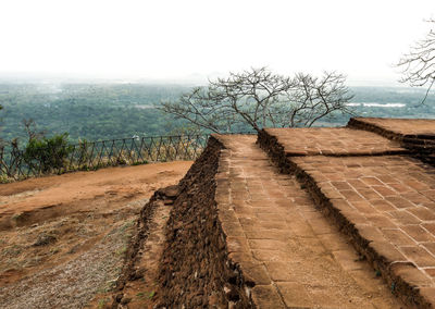 Footpath by road against sky