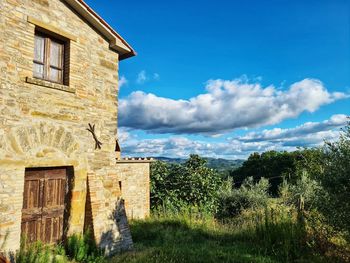 Low angle view of abandoned house on field against sky