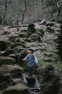 Rear view of man standing in forest