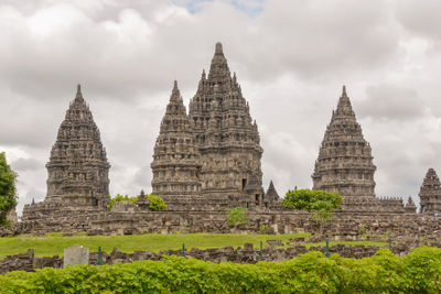 Low angle view of prambanan temple compounds against cloudy sky, indonesia