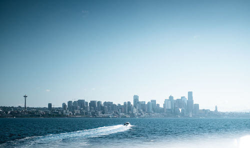 Scenic view of sea by buildings against clear sky