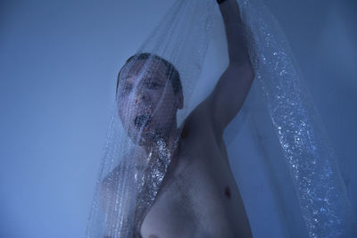 Low section of woman on wet blue sea