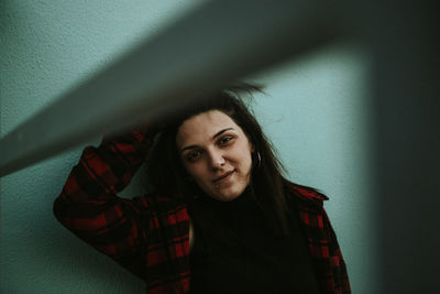 Portrait of smiling young woman against wall at home