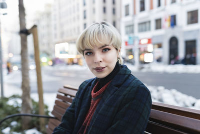 Portrait of young woman in city during winter