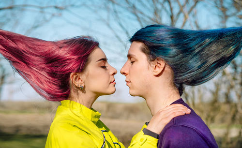 Young couple with colorful hair embracing