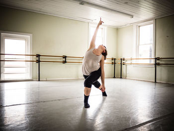 Full length of woman performing ballet dance in studio