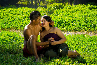 Young couple romancing on grassy field