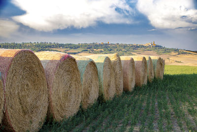 Hay bales on field against sky