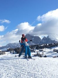 Man skiing on snowcapped mountain against sky