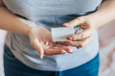 Midsection of woman holding capsule in hand