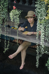 Full length portrait of girl sitting on plants