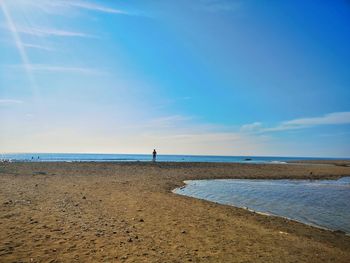 Scenic view of beach against blue sky