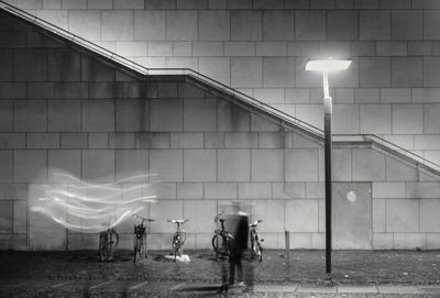 Blur image of person standing against illuminated wall at night