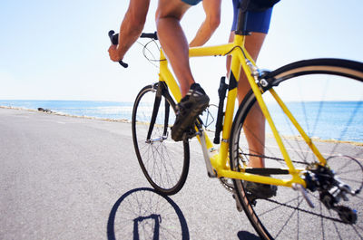 Low section of woman cycling on beach