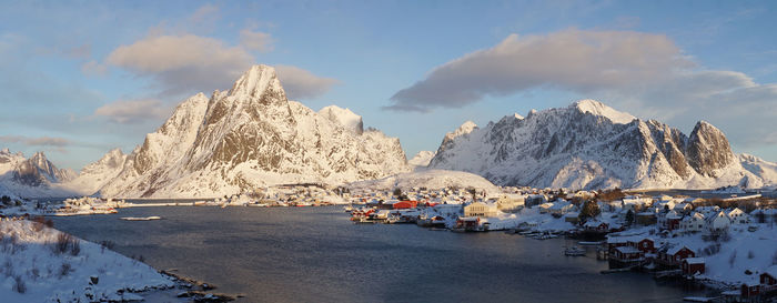 Scenic view of sea and snowcapped mountains against sky