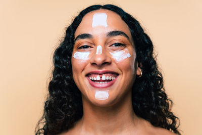 Portrait of young woman against pink background