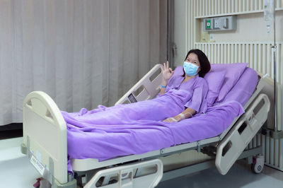 Female patient is smiling and showing ok gesture in hospital room. medical healthcare concept.