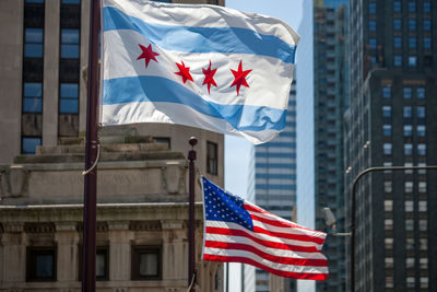 Low angle view of flag against building in city