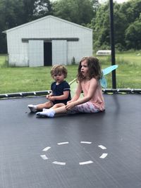 Girl sitting in front of two people