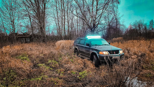 View of abandoned car on field