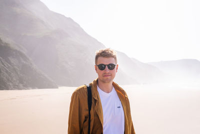 Portrait of young man standing at beach