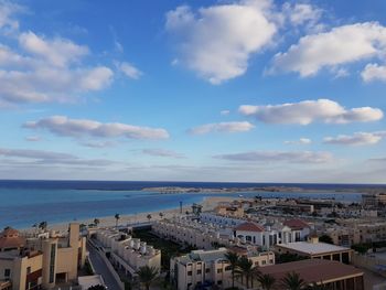 High angle view of townscape by sea against sky