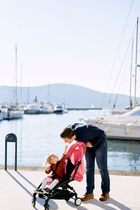 Father and daughter standing at harbor