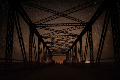 Silhouette of bridge against sky at night