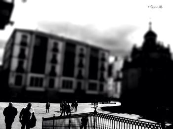 People on buildings in city against sky