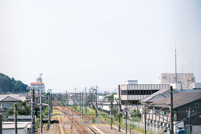 High angle view of railroad tracks by buildings against clear sky